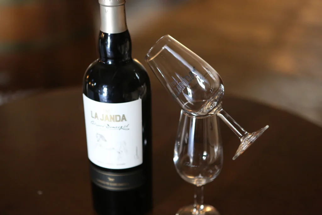 Botella de vino La Janda situada al lado de dos copas.