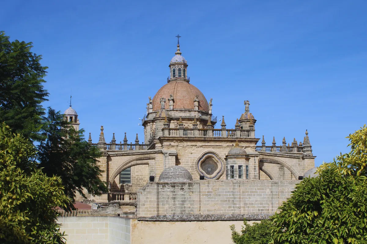 Vista exterior de la Catedral de Jerez de la Frontera con su cúpula y detalles arquitectónicos bajo un cielo azul. Esta imagen se utiliza para ilustrar una entrada sobre cómo organizar una escapada de fin de semana en Jerez para el final del verano.