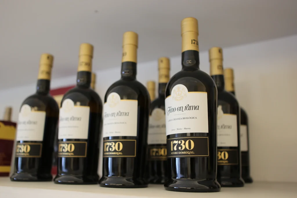 Colección de botellas de vino Fino en Rama 1730 de bodegas Álvaro Domecq alineadas en un estante.