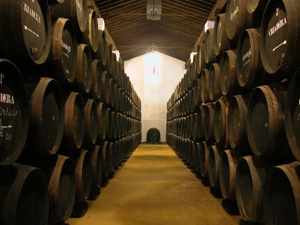 Pasillo central de bodega con hileras de botas de Jerez de Álvaro Domecq